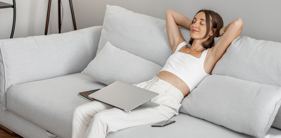 Woman with a laptop on the couch at home