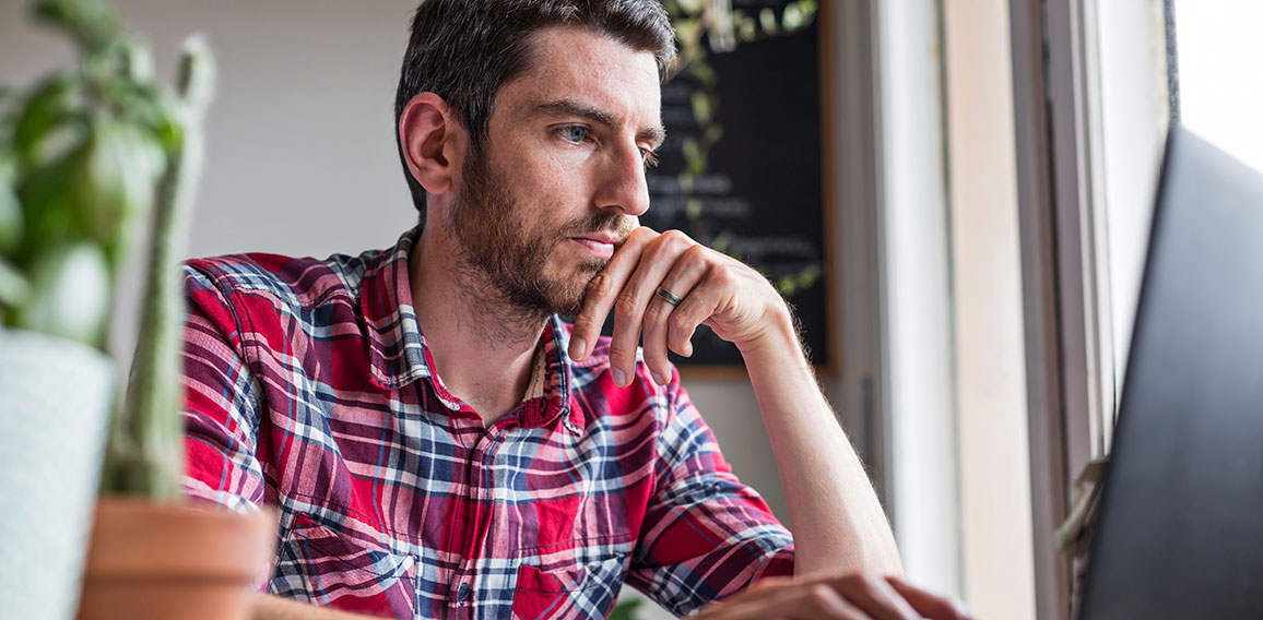 Man using laptop on desk working from home