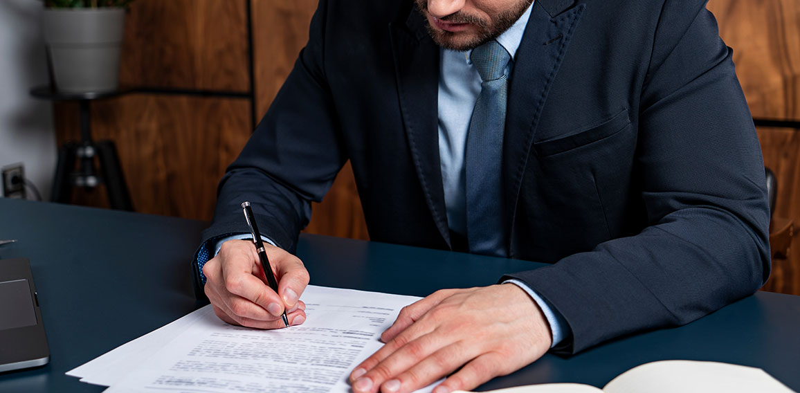 A good looking man signing the mortgage contract at the real property agent office. The concept of entering into legal power to take liabilities. Real eastate.