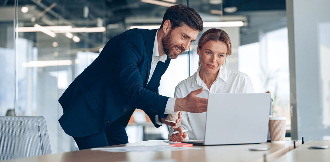 Mature female boss discussing online project with employee