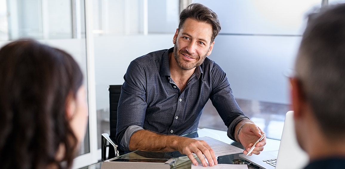 Confident businessman advising couple on finance