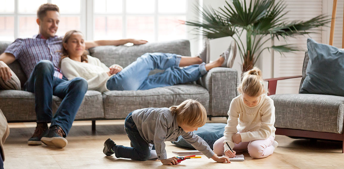 Children siblings playing drawing together while parents relaxin