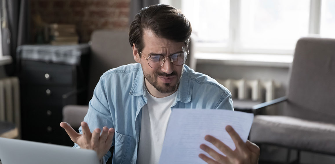 Annoyed frustrated entrepreneur looking at paper report with bad news