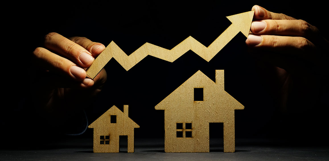 Property investment. Models of house and hand holding arrow.