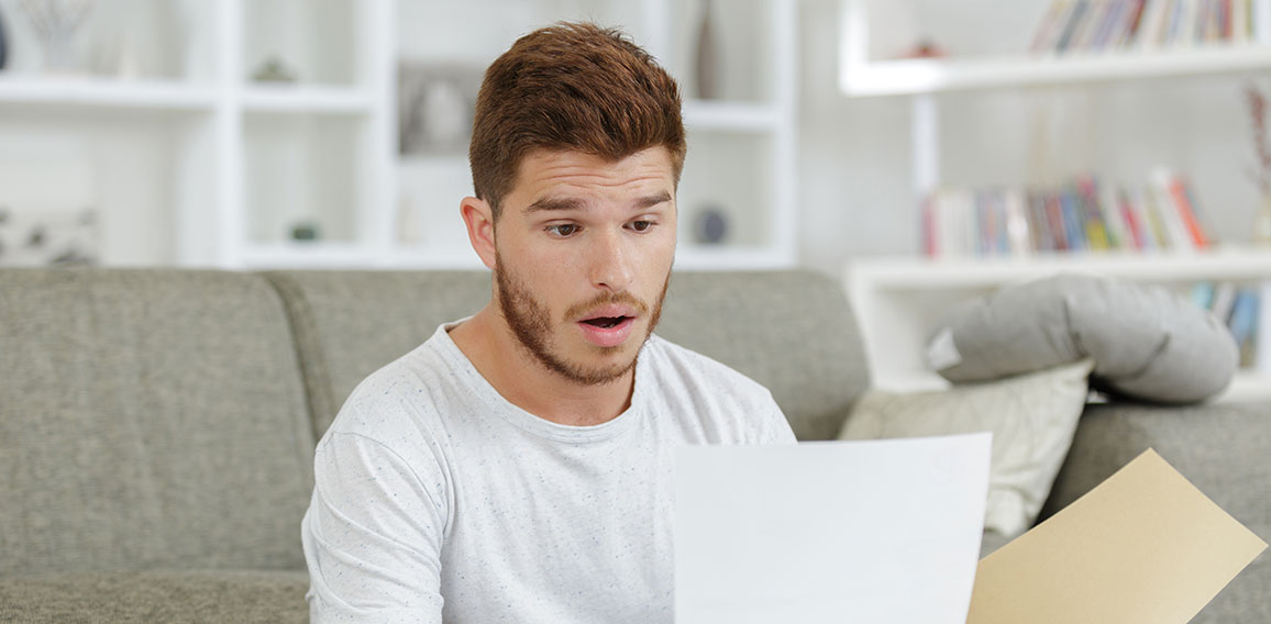 surprised man looking at paper