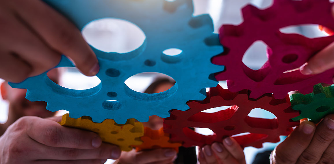 Teamwork of business people work together and combine pieces of gears