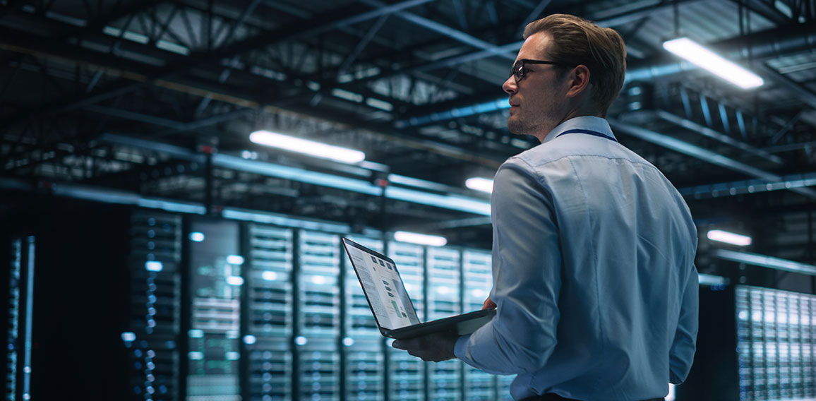 Data Center Male It Specialist Using Laptop while Working on Com