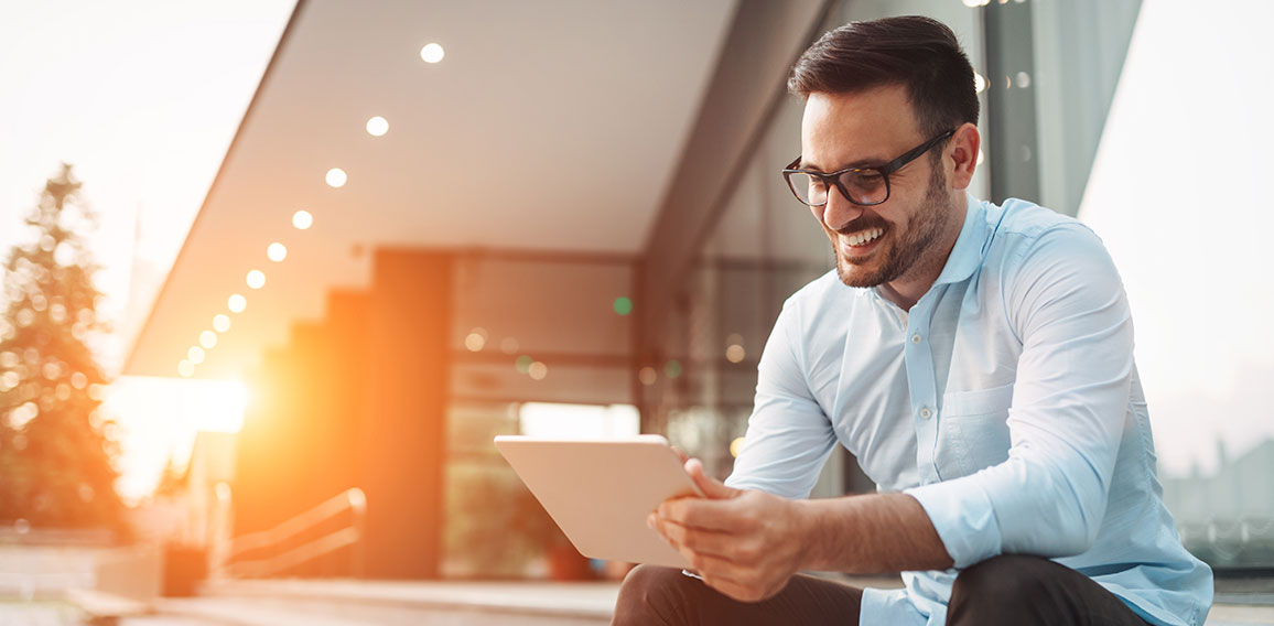 Portrait of businessman in glasses holding tablet