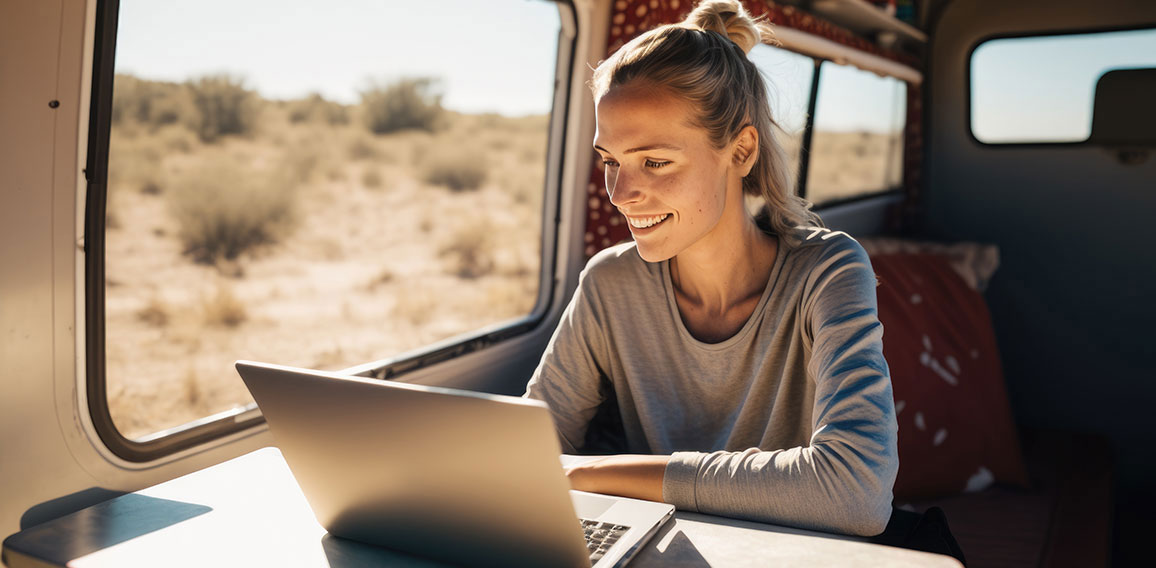 Digital Nomad Woman Using Laptop Inside Her Camper Van, Happy Developing Her Passion on a Sunny Day. Concept of Digital Nomads and Entrepreneurial Women