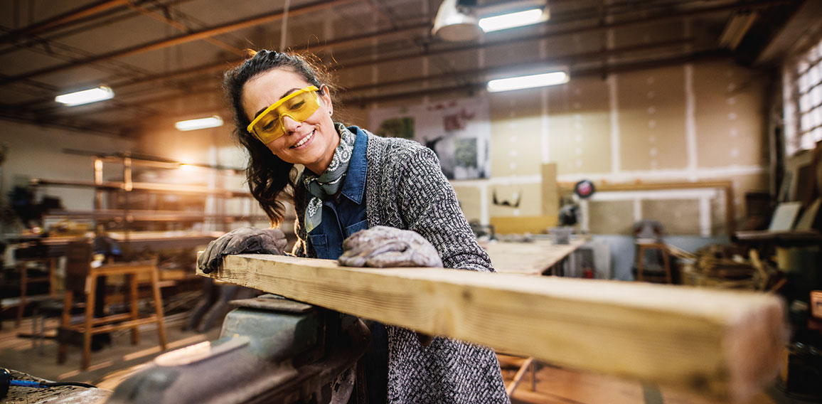 Professional carpenter woman choosing and preparing wood at stee