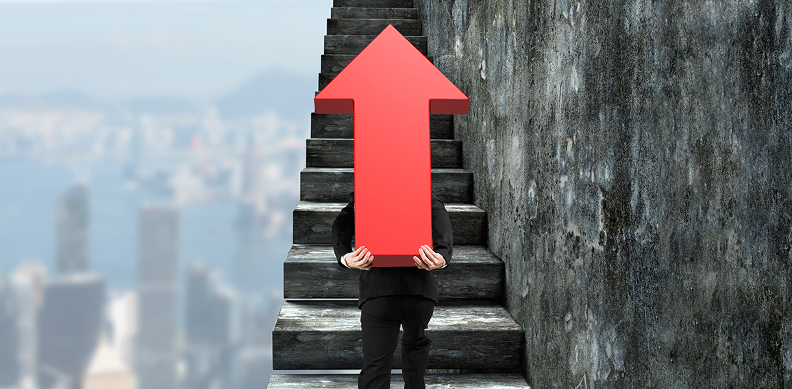 Businessman carrying red arrow sign climbing on stairs