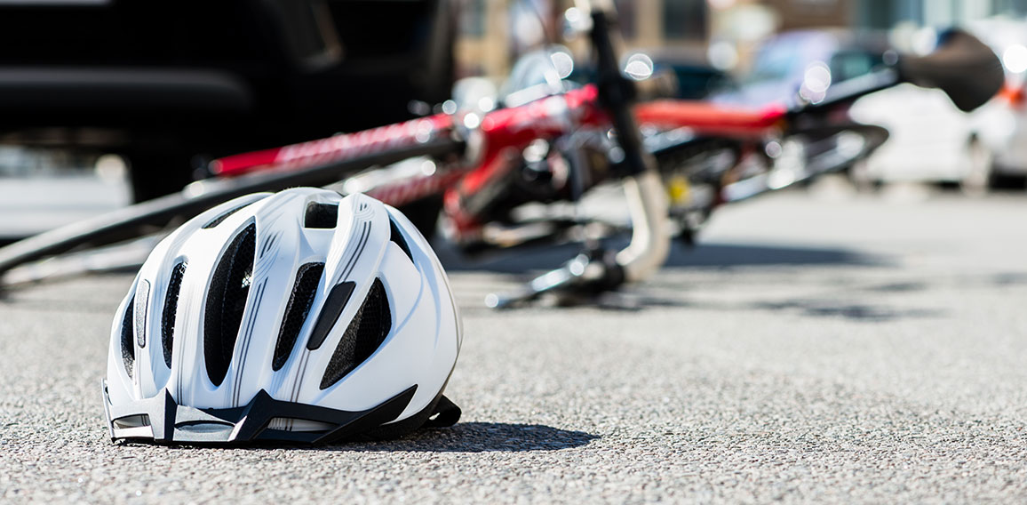 Close-up of a bicycling helmet on the asphalt  next to a bicycle