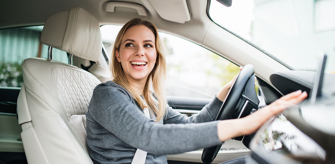 Young woman driver sitting in car, driving.