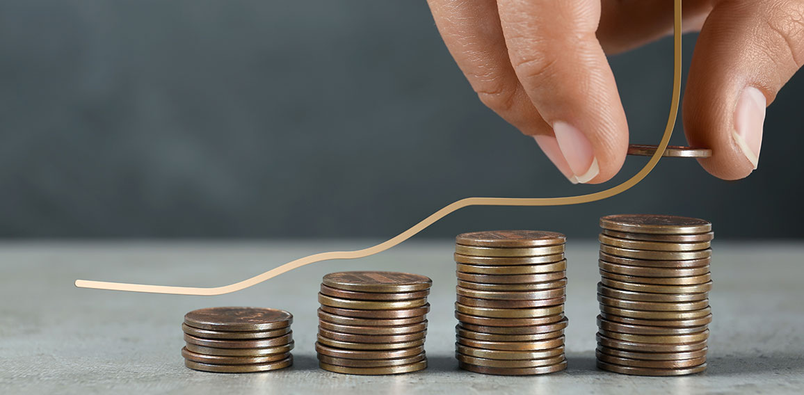 Salary increase concept. Woman stacking coins on grey table and