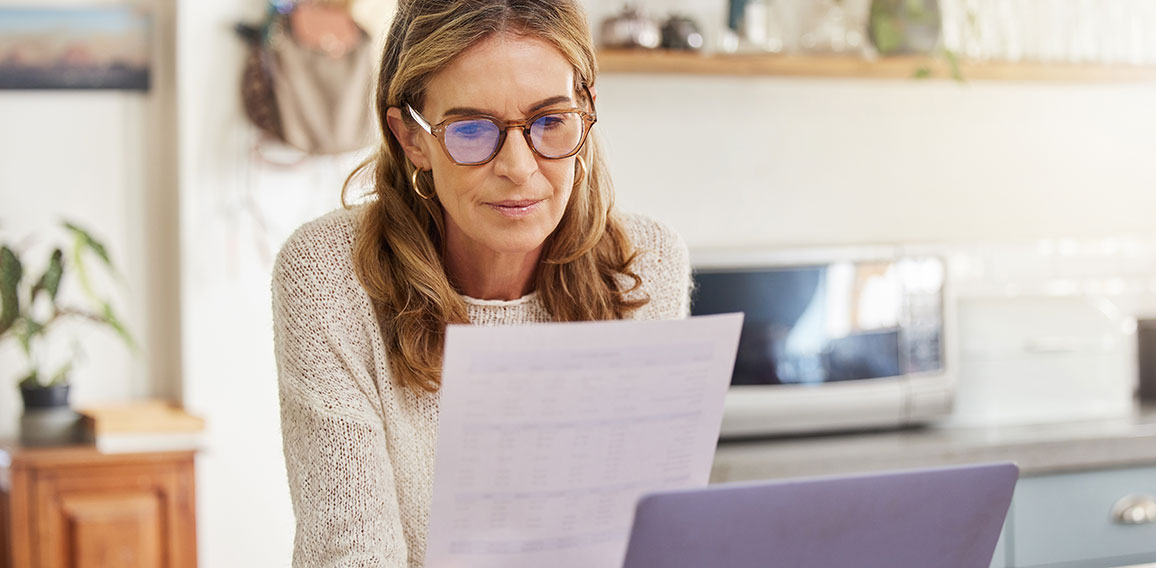 Budget, finance and retirement woman with laptop and paperwork for pension savings, bills or income investment on digital bank app. Elderly person with mortgage, financial document or tax management