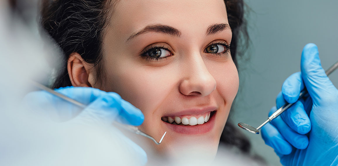 Smiling woman sitting in dentist chair ready for a dental check-