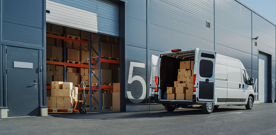 Outside of Logistics Warehouse with Open Door, Delivery Van Load