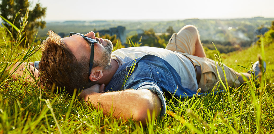 Man lying on grass enjoying peaceful sunny day