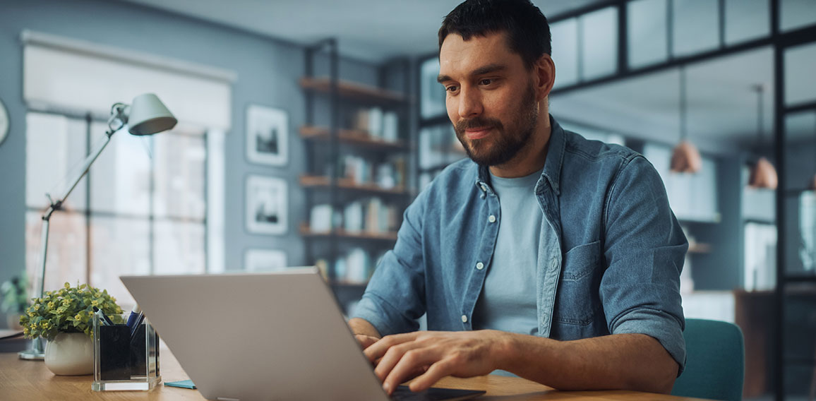 Handsome Caucasian Man Working on Laptop Computer while Sitting