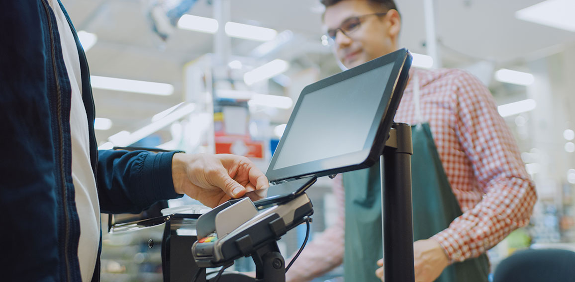 At the Supermarket: Checkout Counter Customer Pays with Smartpho