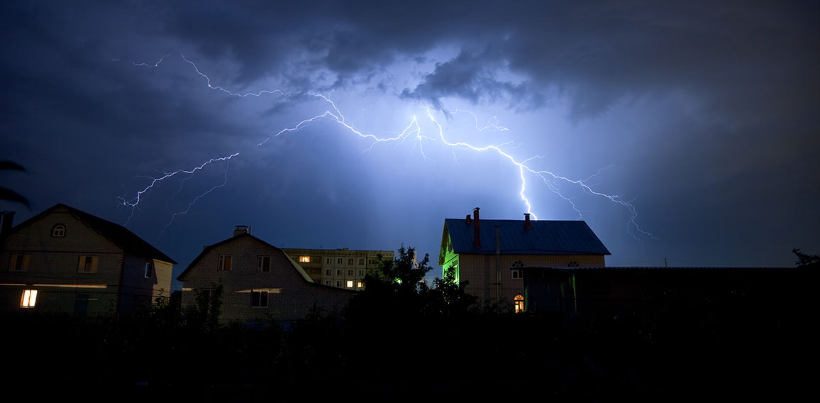 Lightning in the cloudy sky over village