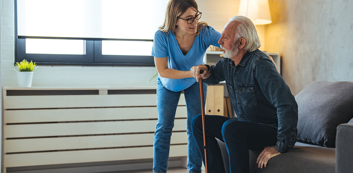 Young caring nurse helping senior old elderly man grandfather wa