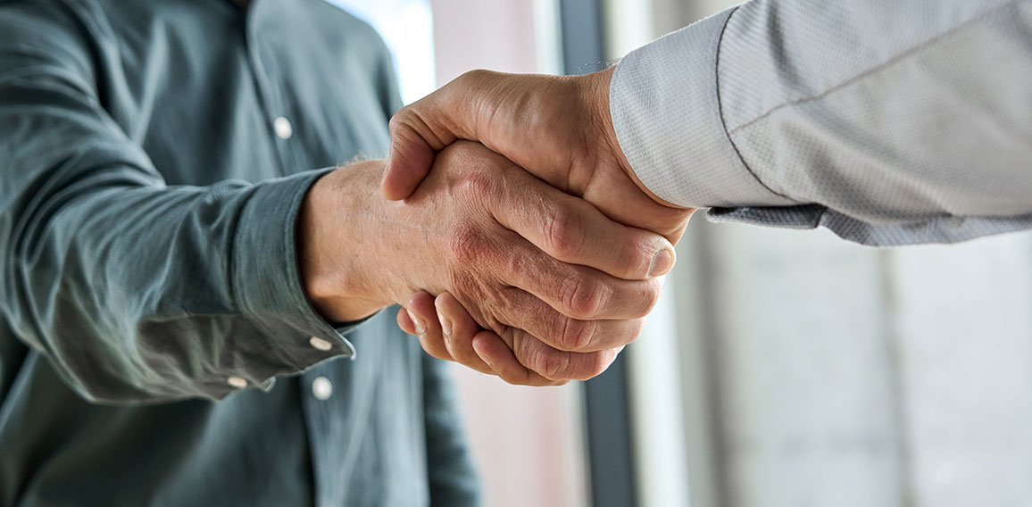 Two happy professional businessmen shaking hands at meeting. Handshake