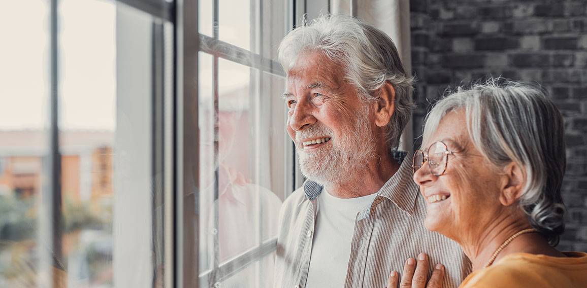 Happy bonding loving middle aged senior retired couple standing