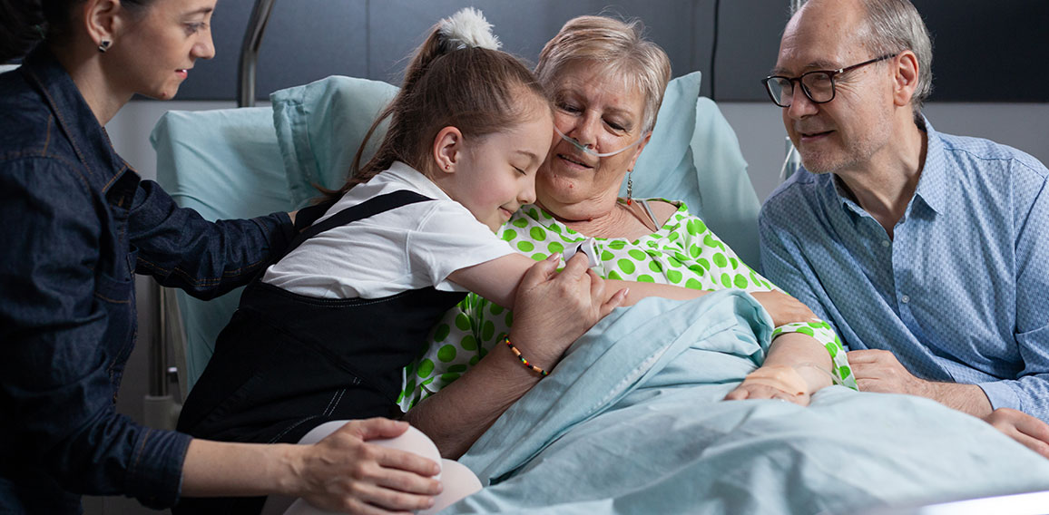 Little girl greeting grandmother with hug at hospital