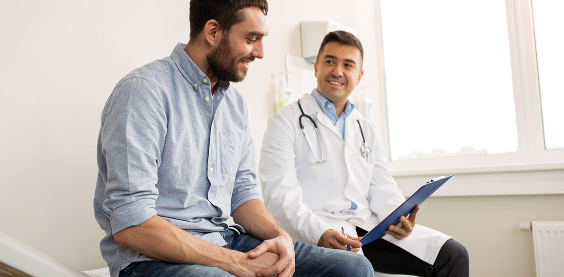 smiling doctor and young man meeting at hospital