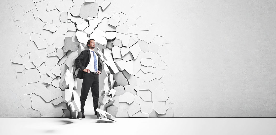 businessman breaking trough a wall