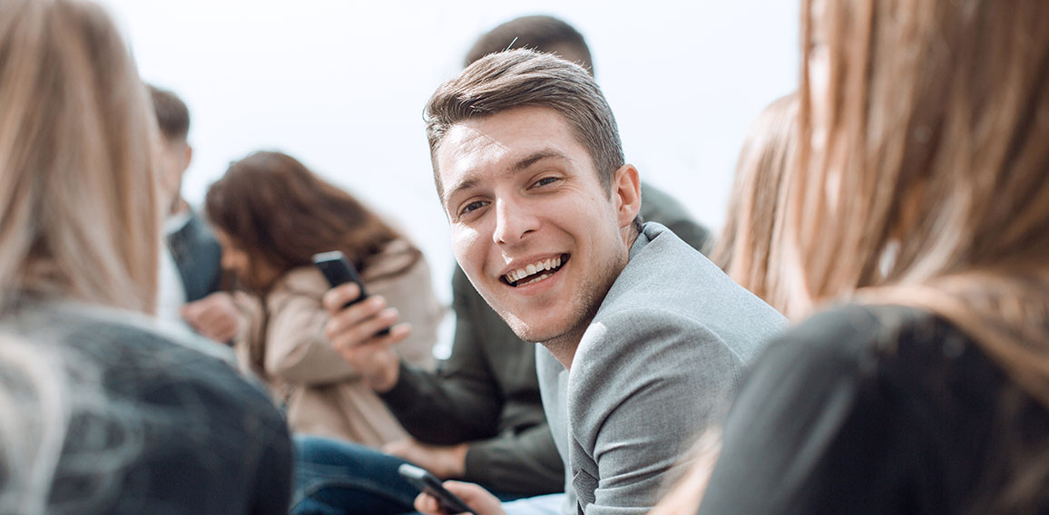 smiling guy sitting in a circle at a group meeting