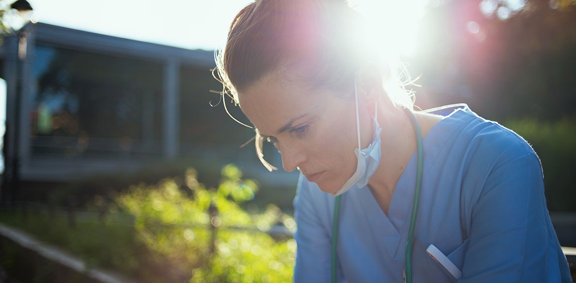 tired modern medical doctor woman sitting outside near clinic