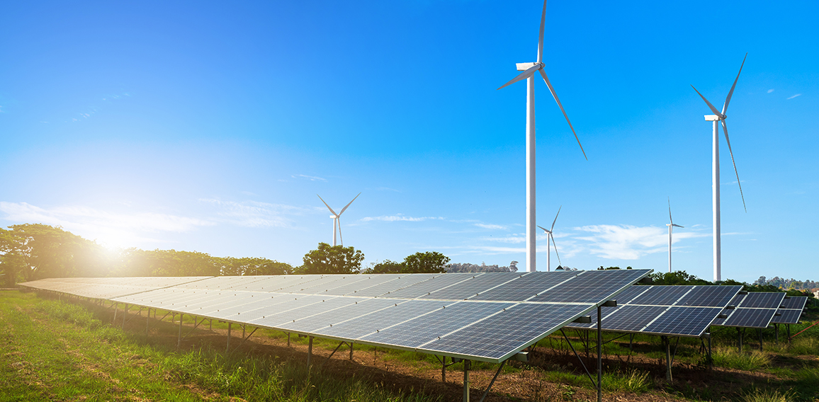 solar panels with wind turbines against mountanis landscape agai