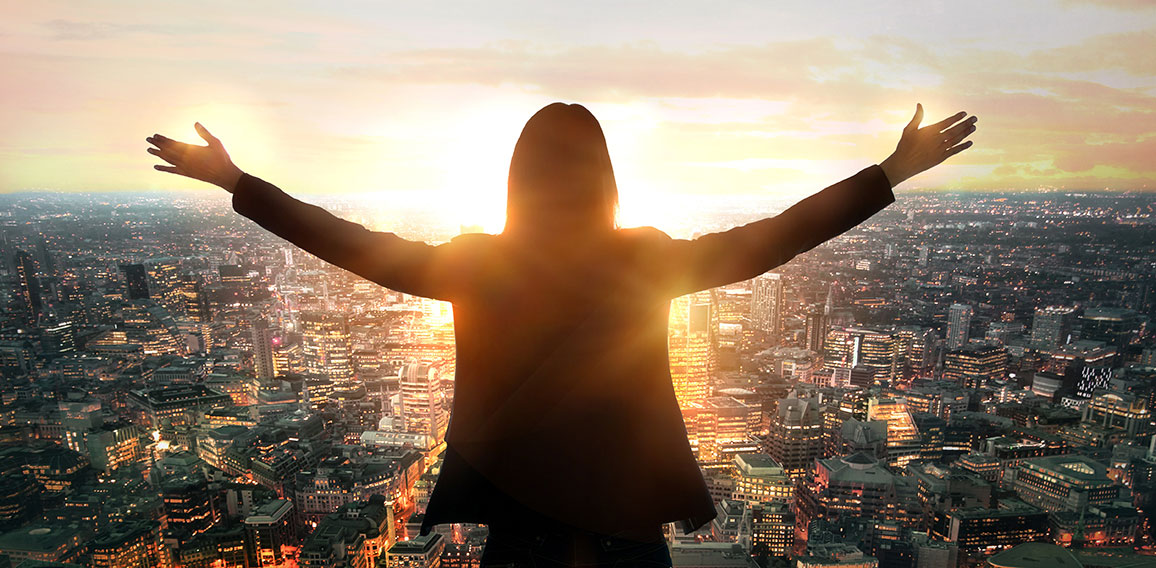 Young woman looking at the City of London at sunset. Planning th