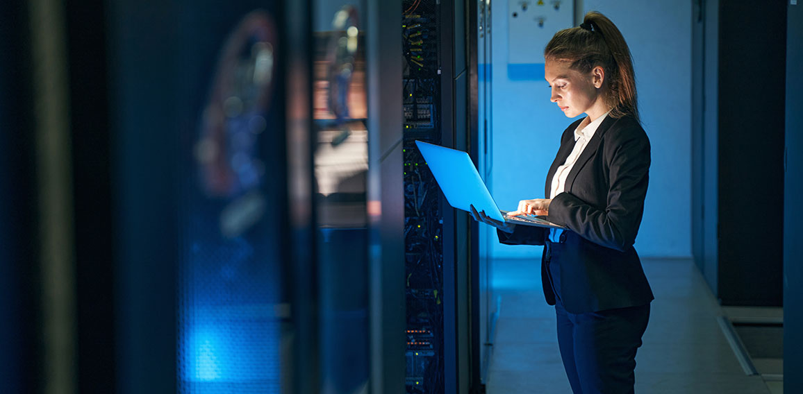 Female engineer working in server room at modern data center