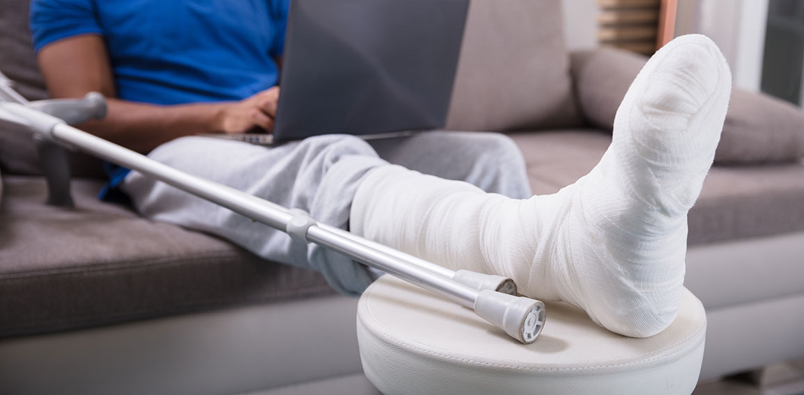 Man With Broken Leg Using Laptop