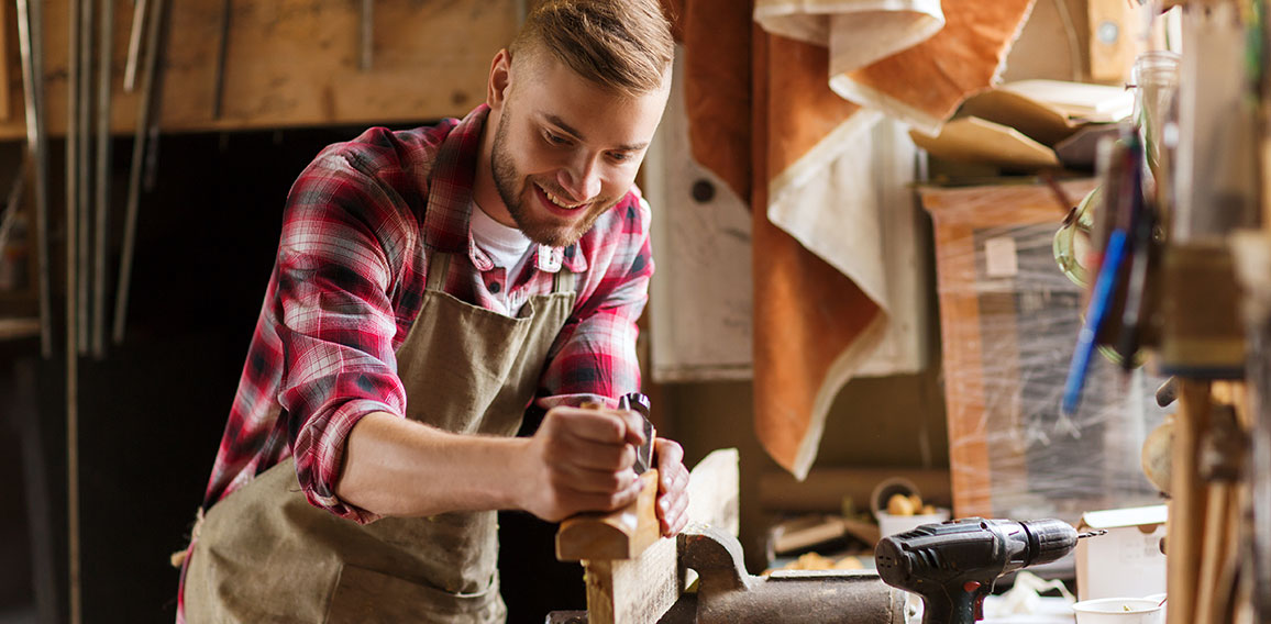 carpenter working with plane and wood at workshop