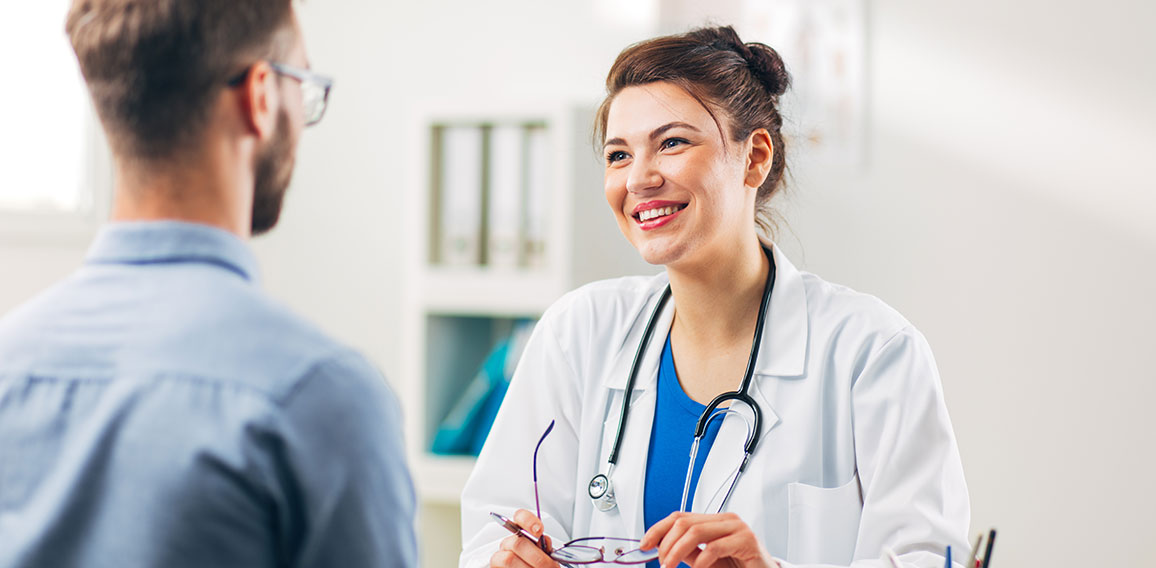 Woman Doctor talking to Patient at her Medical Office