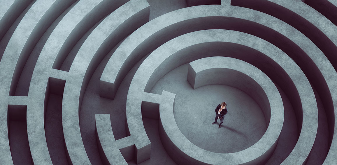 Confused businessman thinks how to find the right way to exit from a big maze