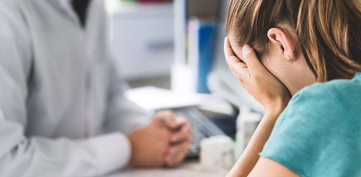 Sad patient visiting doctor. Young woman with stress or burnout