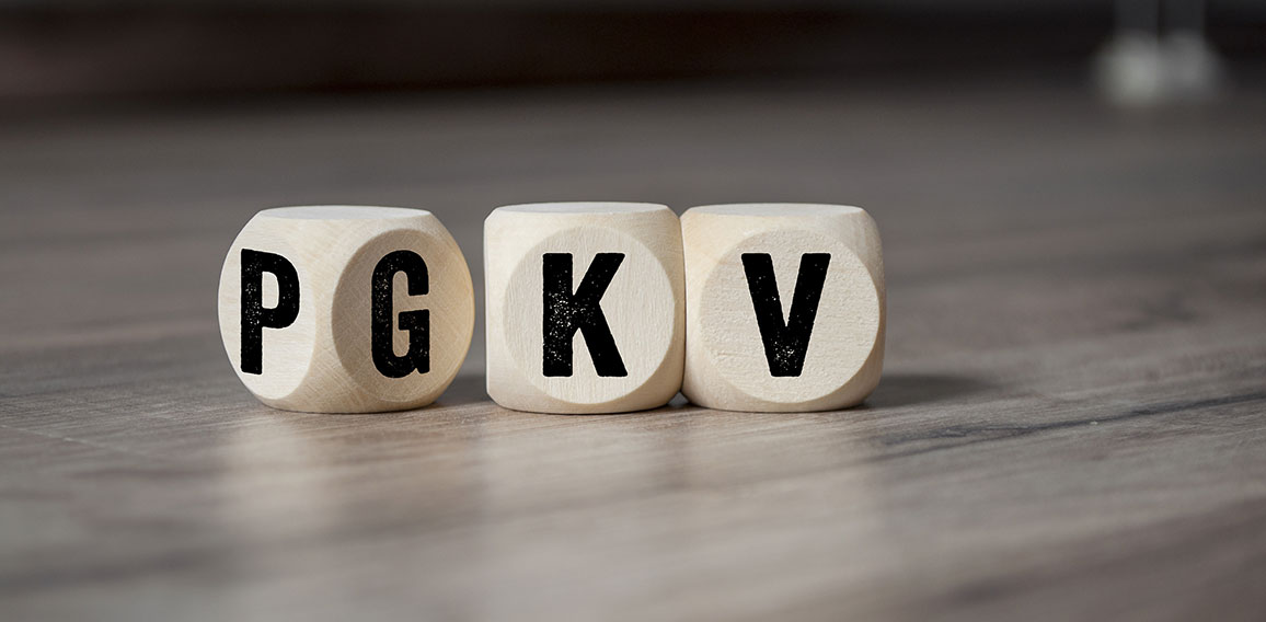 Cubes and dice with the acronyms PKV and GKV on wooden backgroun