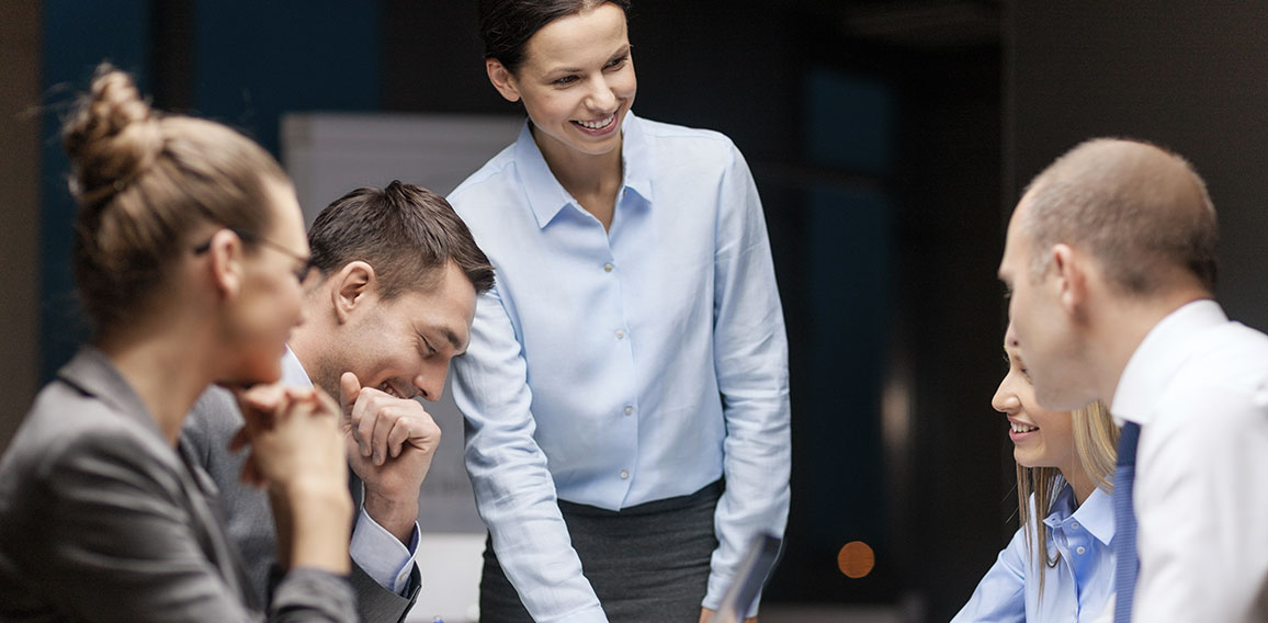 smiling female boss talking to business team