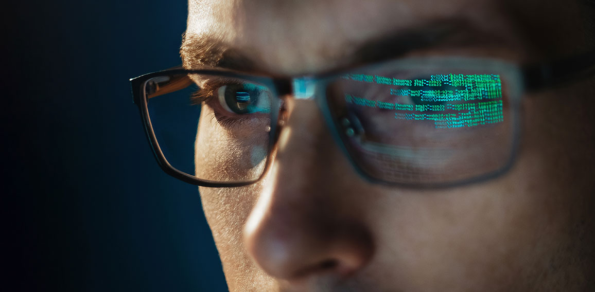 Close-up portrait of focused software engineer wearing eyeglasses