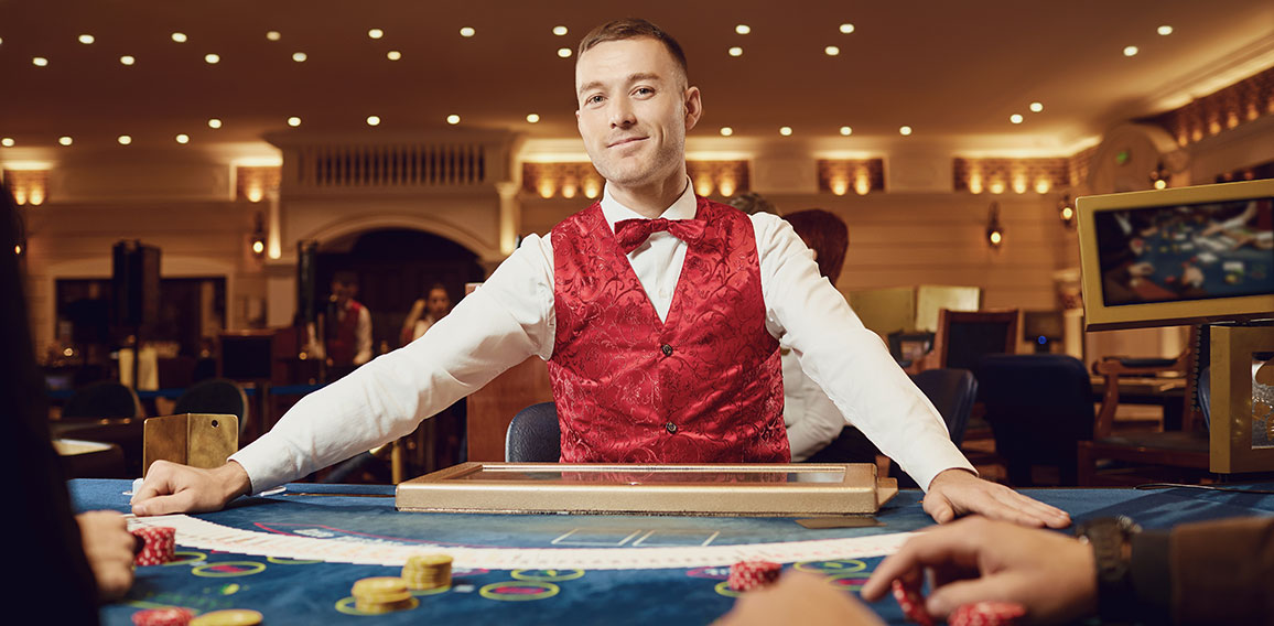 Croupier holds poker cards in his hands at a table in a casino.