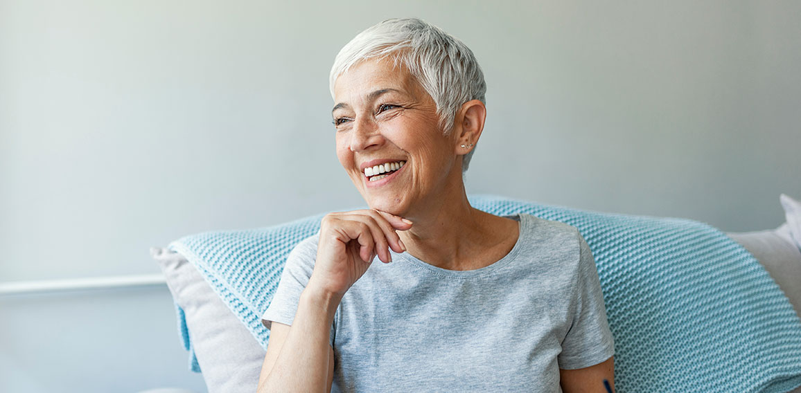 Happy woman relaxing on her couch at home in the sitting room. P