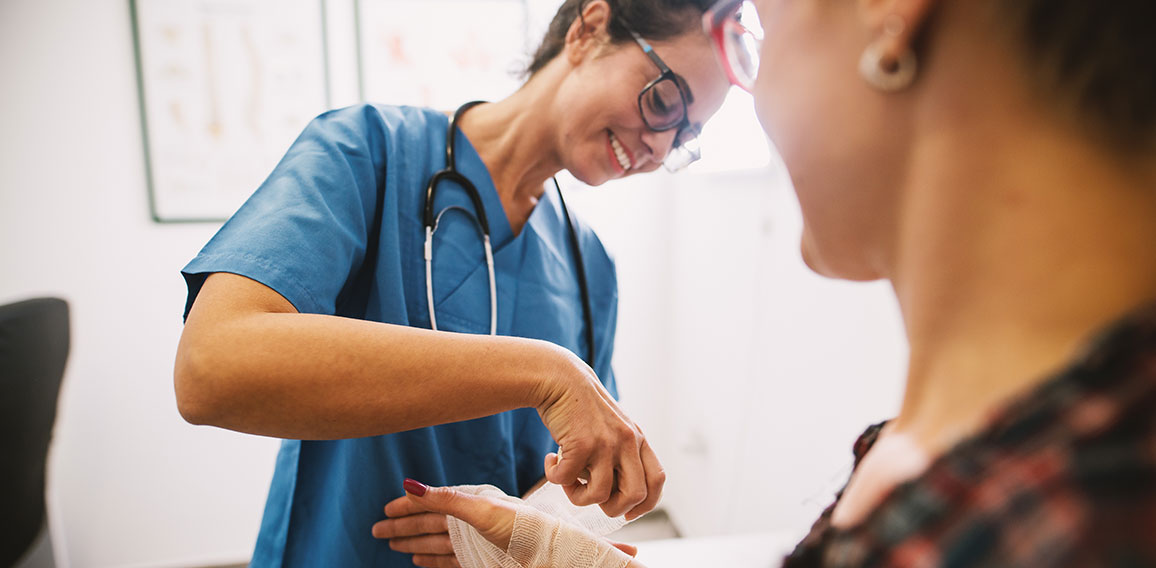 Professional nurse at the hospital bandaging the hand with a med