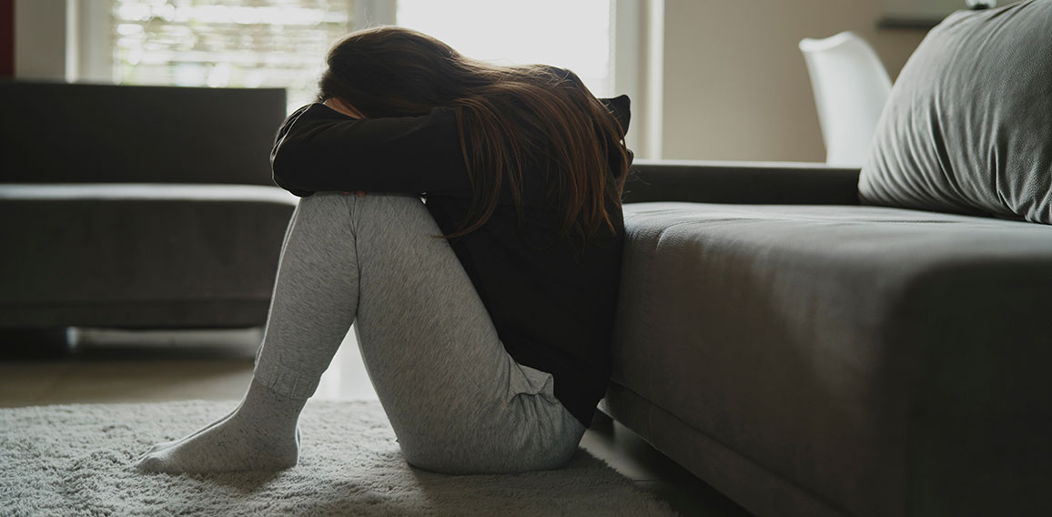 Caucasian broken woman sitting at the floor in living room