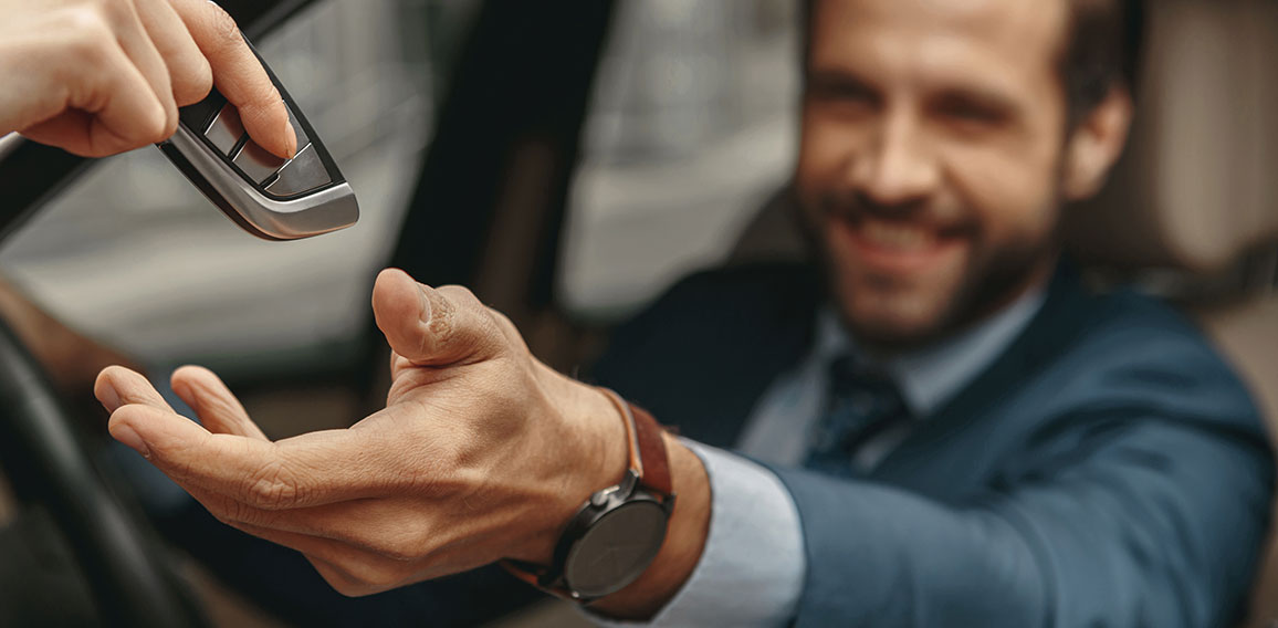 Image of man getting the keys to the automobile from the seller