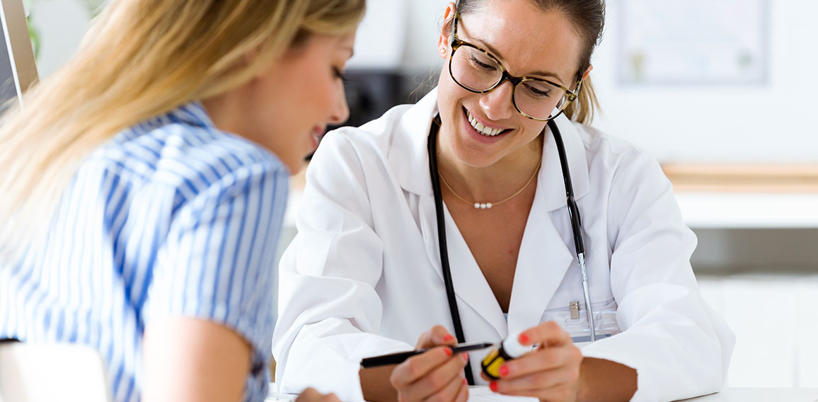 Female doctor prescribing medication for patient.